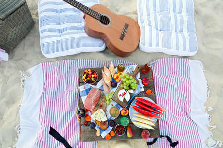 Picnic on the beach at sunset in the style of boho. Food and drink, relax, holiday conceptの写真素材