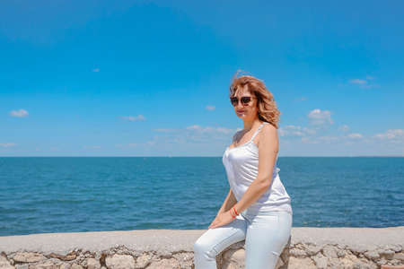 Portrait of the active and attractive middle aged woman wearing sunglasses enjoying happy retirement with holiday at beachの写真素材