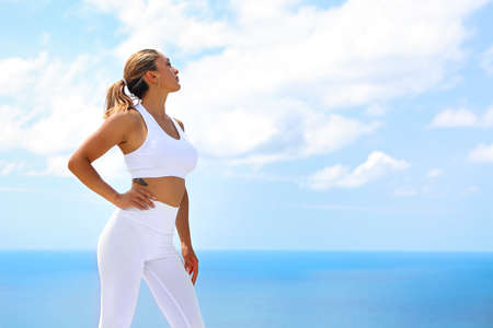 Beautiful young woman making stretching exercises in the beach 

の写真素材