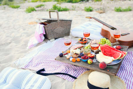 Picnic on the beach at sunset in the style of boho. Food and drink, relax, holiday conceptの写真素材