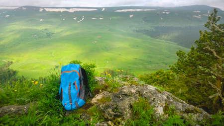 Blue backpack in the mountains with views of the mountains on a sunny day