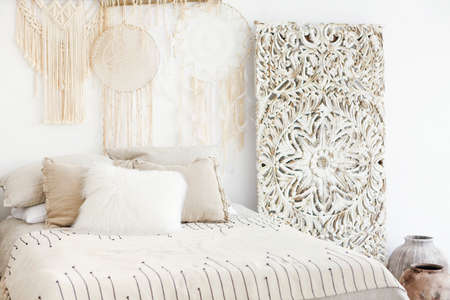Comfortable canopy bed with soft pillows located in light minimalist bedroom in modern apartment
