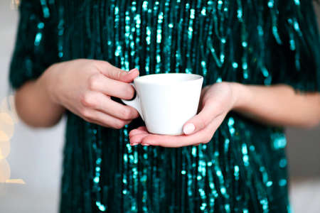 Stylish lady sniffing aromatic hot drink while resting in brightly illuminated cafeの写真素材