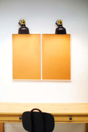Framed cork notice boards with copy space for paper notes and stickers. Retro lamp over them. Home office conceptの写真素材