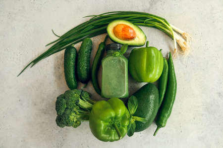 Healthy green detox juice over gray background. Flat lay