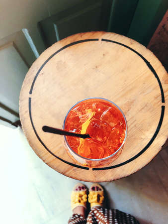 Anonymous female and goblet of alcohol cocktail with cherries and black straw on blurred bar backgroundの写真素材