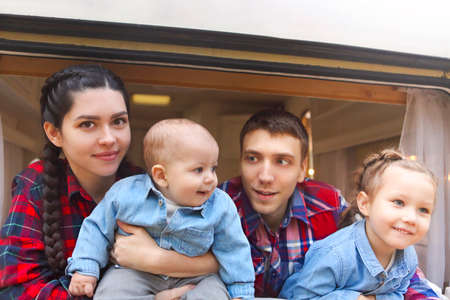 Portrait of the smiling happy family with kids in the house on wheels indoorの写真素材