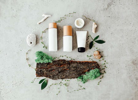 Top view of bottles with cosmetic products placed on various organic ingredients for spa procedureの写真素材