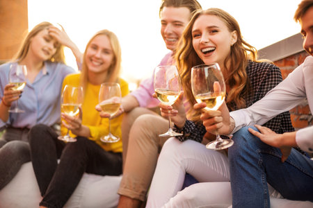 Happy man and woman with alcohol drinks smiling during meeting with friend