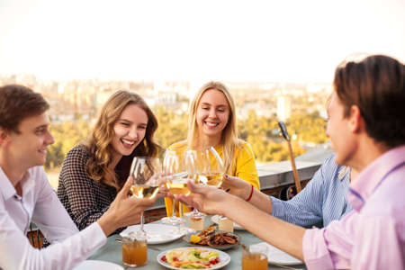 Cheerful man and women smiling while sitting at table during banquet