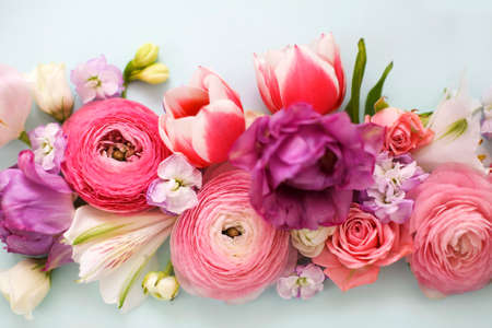 Top view of organic fresh flowers arranged in beautiful compositions on blue background