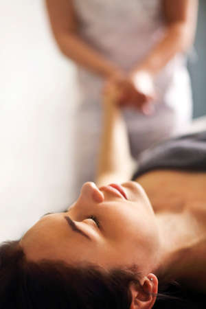 Faceless master massaging arm and wrist of woman lying on table in massage salonの写真素材