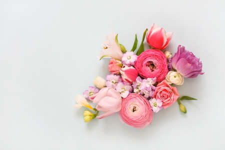 Top view of organic fresh flowers arranged in beautiful compositions on light blue backgroundの写真素材