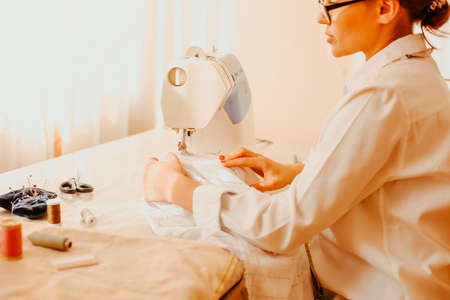 Side view of talented female designer creating garment while working with mannequin in atelier
