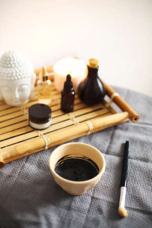 From above of aromatherapy candles and assorted skincare products placed on wooden tray in spa salonの写真素材