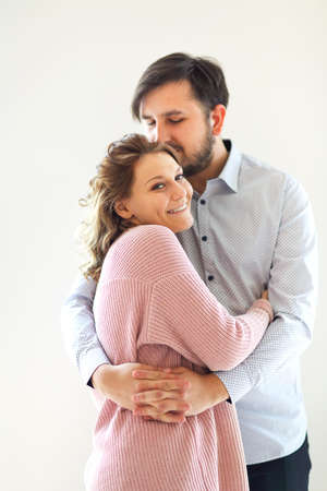 Side view of content loving couple gently embracing on white background at homeの写真素材
