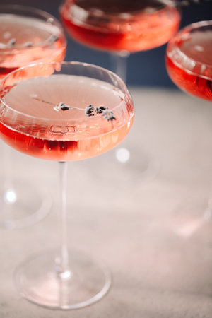 Set of glass goblets with champagne and flowers placed on table in restaurantの写真素材