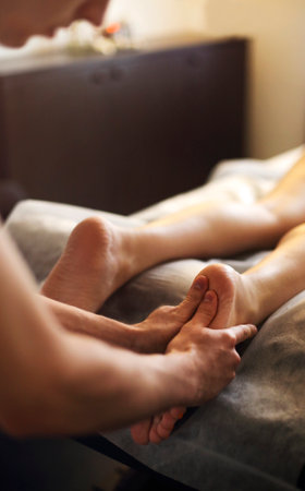 Foot massage, spa foot treatment. Medical massage at the leg in a physiotherapy centeの写真素材