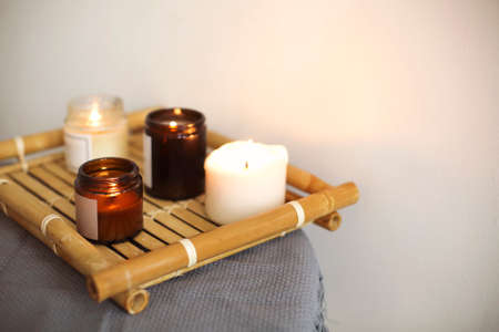 Lighting candle in jar on the table with trayの写真素材