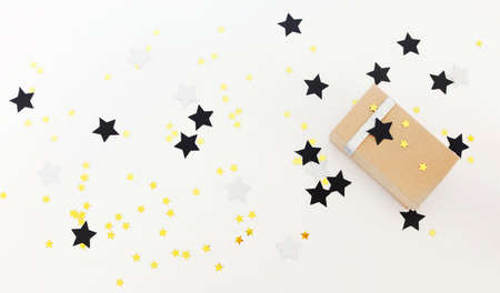 Top view of stylish gift box decorated with berries and stars placed on wooden tabletop during...
