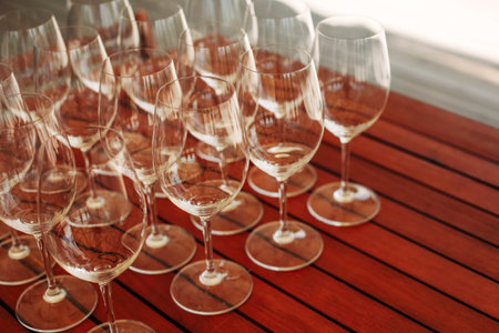 Lots of empty glasses at the reception. Close-up of a row of glasses prepare for the service for outdoors dinnerの写真素材