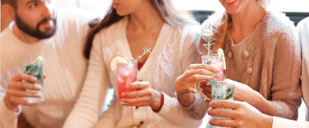 Young men and women drinking cocktail at party. Celebration and party conceptの写真素材