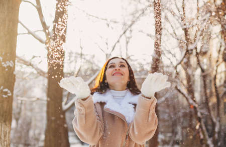 Optimistic young woman smiling while having fun on street on sunny winter dayの写真素材