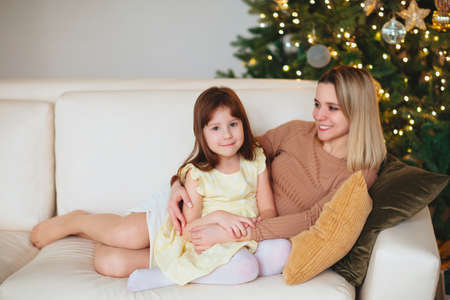 Happy playful little girl daughter playing with positive mother, spending time together during...