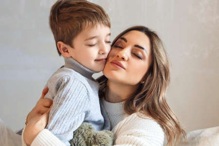 Raising Kids With Love. Cute family portrait of loving mother and little boy son hugging, isolated...