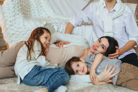 View from above of big family with two third kids expecting new baby, waiting for child. Pregnant...