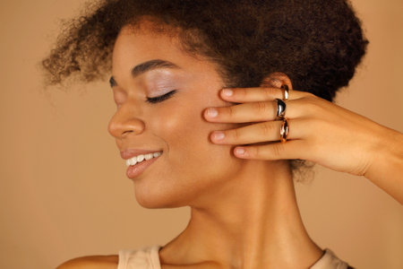Stylish portrait in profile of young smiling beautiful afro american woman with natural makeup...