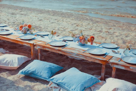 Delicious food and flowers for outdoor summer or spring picnic. Lunch on the beach in romantic colorsの写真素材