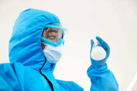 Female lab scientist examining samples in a test tube, working in an african american woman genetic...
