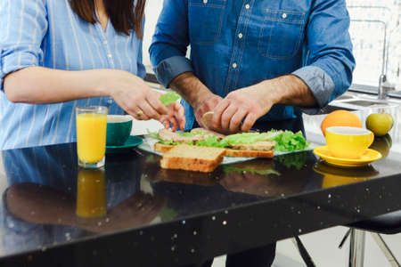 Man talking with his wife cooking food healthy enjoying preparing romantic dinner in kitchen. couple preparing dinner. Healthy food, diet. Cooking together at modern kitchenの写真素材