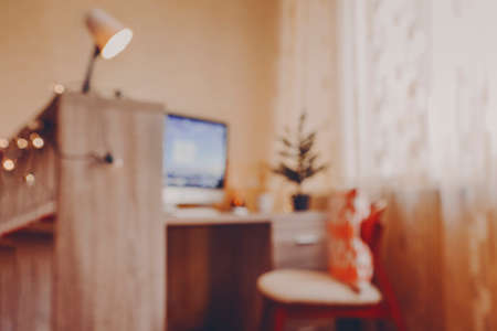 Computer on table in room. Celebration of Christmas online due holiday preparation. Empty modern decorated workplace with computer video call advent friends, home office indoors. Blurの写真素材
