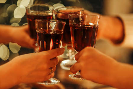Family friends have fun together in winter eating food on a wooden table. concept of friendship. Joyful people enjoying celebration at home or restaurant. holiday conceptの写真素材