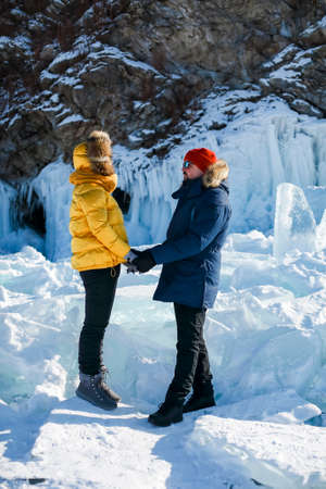 Happy couple on the frozen winter Lake Baikal. transparent ice. Travel in winter, active recreation, sports, holiday.の写真素材