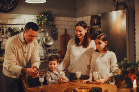 Happy joyful family parents with two kids pouring homemade eggnog into glasses while standing behind...