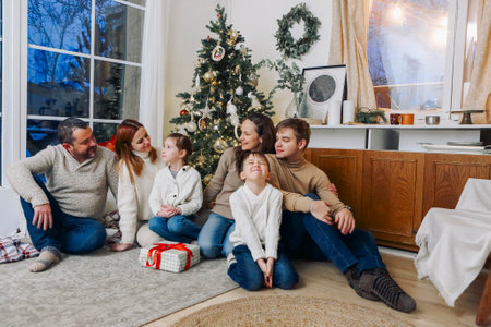 Merry Christmas and Happy New Year! Holiday concept. Mother, father and children decorate the tree in the room. Loving family indoors. big family togetherの写真素材