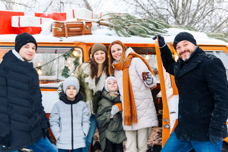 Happy family of travelers in minivan lying together at open rear doors and smiling at camera. Joyful...