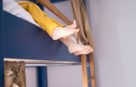 Caucasian little siblings are sitting on the bunk bed. Concept of love, relation, bonding friendship of brother and sister in family lifeの写真素材