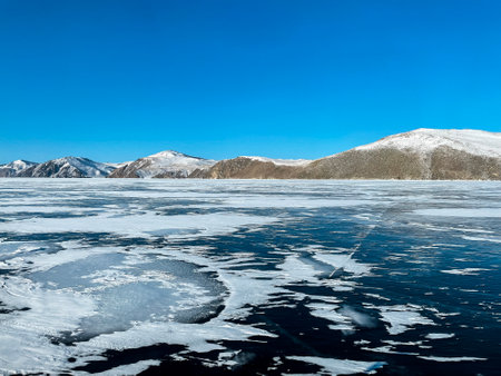Texture of beautiful blue ice with cracks and air bubbles in the frozen lake. Winter nature abstract background. Lake Baikal, Siberia, Russia.の写真素材