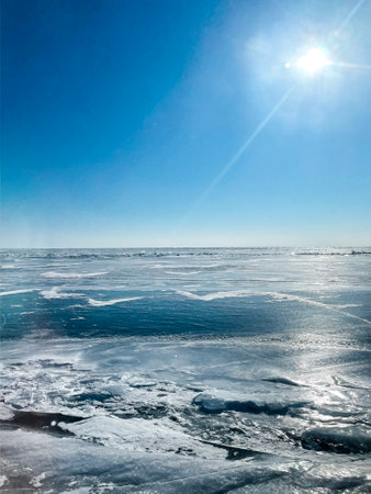 Texture of beautiful blue ice with cracks and air bubbles in the frozen lake. Winter nature abstract background. Lake Baikal, Siberia, Russia.の写真素材