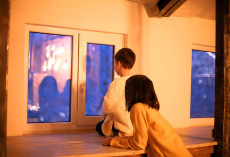 Cute children waiting for miracle on Christmas Eve at home, small kids sister and brother hugging while sitting together near the window, selective focusの写真素材