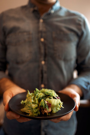 Healthy lifestyle. Man Cooking Green Salad Of Romaine Lettuce. healthy food concept