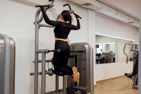 Attractive brunette sportive woman doing exercises on the simulator in fitness club. Sport,...