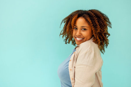Cheerful good looking carefree young african american woman showing calm down, assure all fine and smiling, standing blue background satisfied. happy black femaleの写真素材