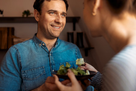 Happy adult couple eating healthy food in loft kitchen. Healthy food and care conceptの写真素材