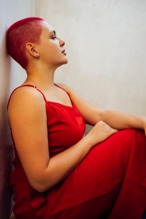 Beautiful relaxed woman in red long dress and red shot hair looking good. concept of body positive