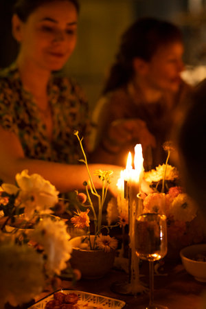 Many people saying cheers and showing their champagne glasses full of sparkling wine to each other whilst enjoying an outdoor wedding party on a backyard restaurant at sunsetの写真素材